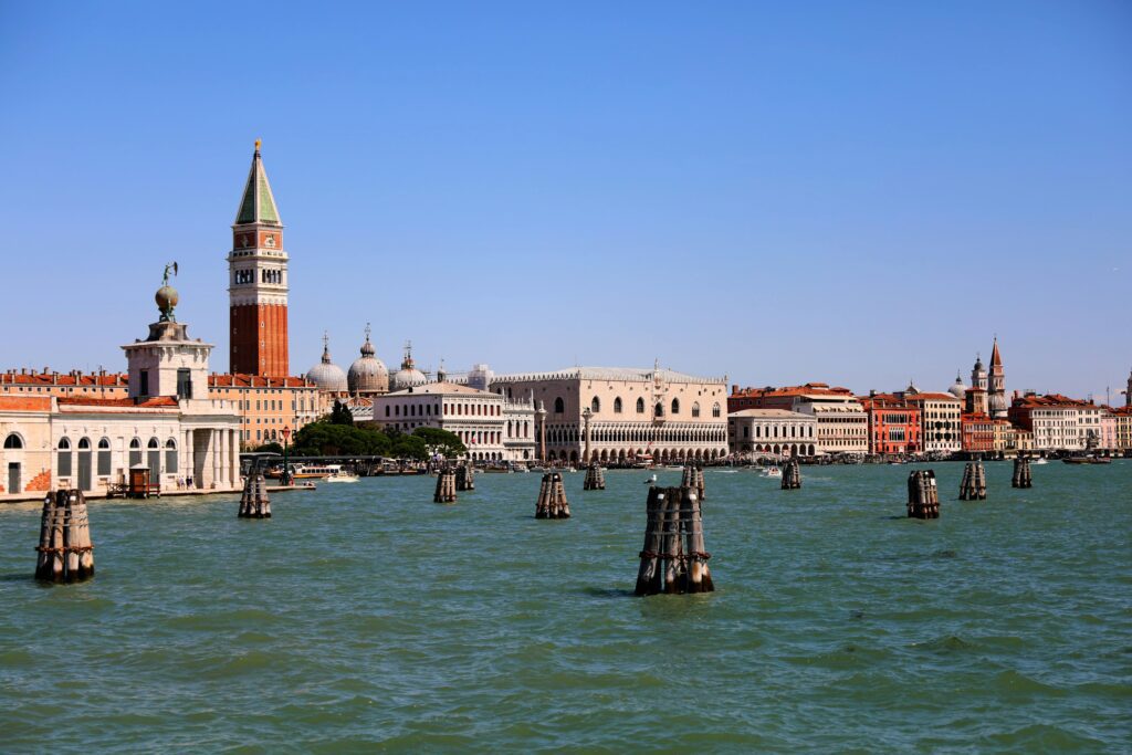 Stunning view of Venice's historic waterfront with St Mark's Campanile under a blue sky.
